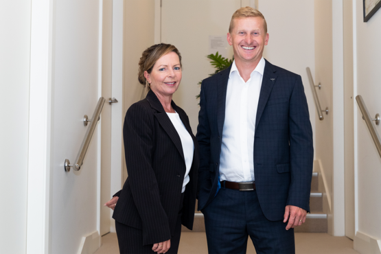 2 people in business attire standing